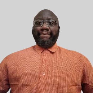 Headshot of a man in an orange shirt.
